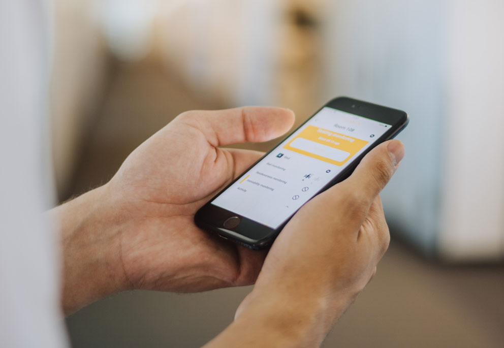 Helsepersonell ser på QUMEA-appen på en mobiltelefon